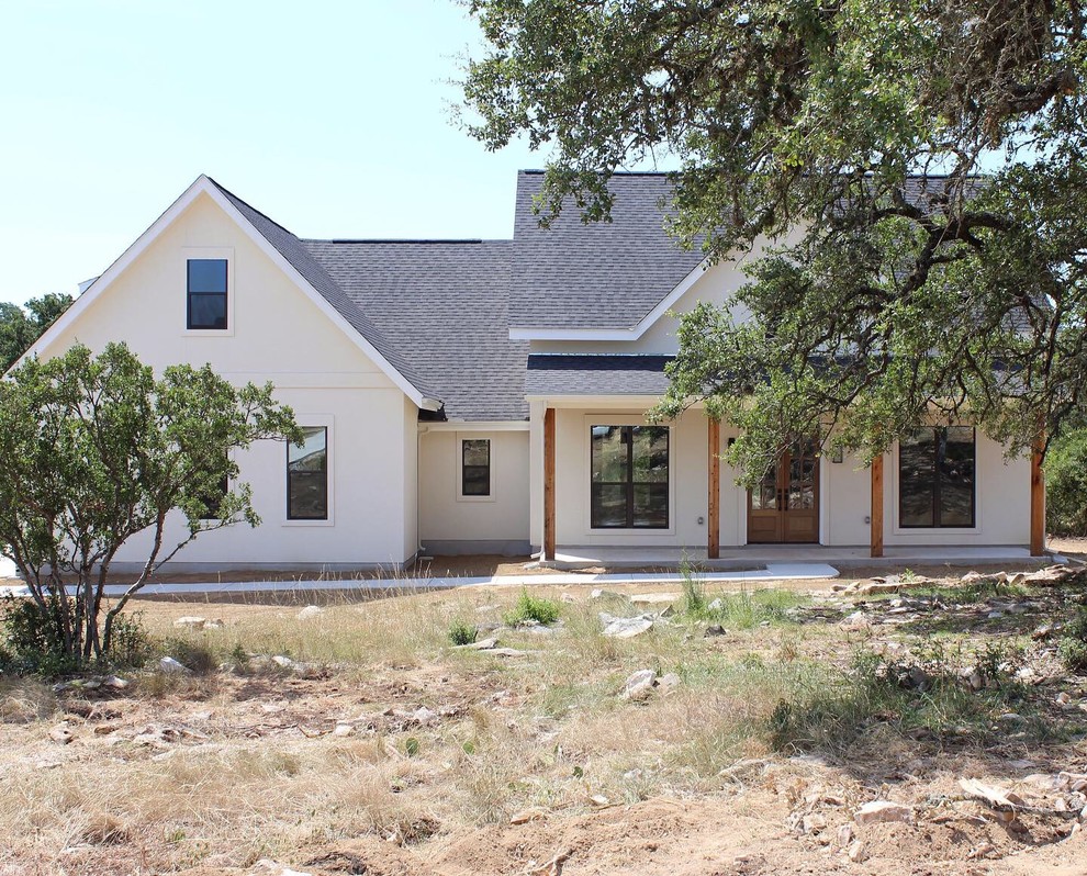 Photo of a medium sized and white farmhouse two floor render detached house in Austin with a shingle roof.