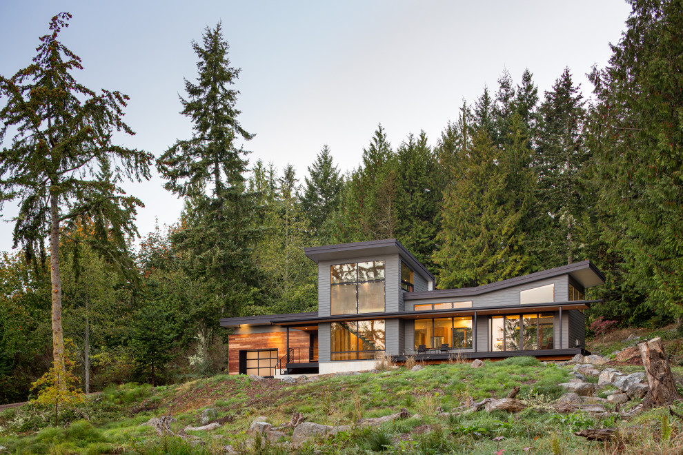 Mittelgroßes, Einstöckiges Modernes Einfamilienhaus mit Faserzement-Fassade, grauer Fassadenfarbe, Pultdach, Blechdach, schwarzem Dach und Verschalung in Seattle