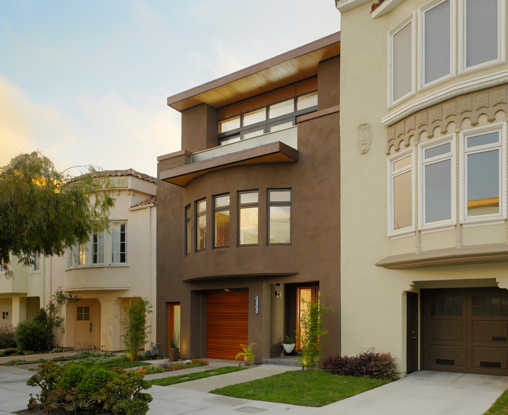 Ejemplo de fachada marrón minimalista de tres plantas con revestimiento de estuco y tejado plano
