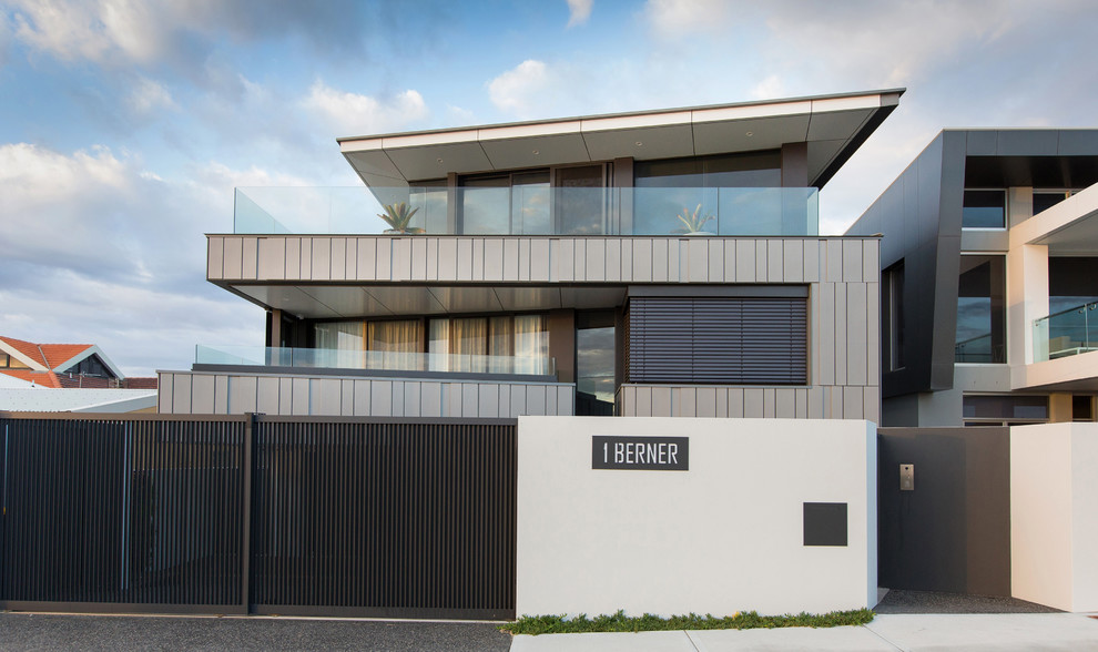 Идея дизайна: большой, трехэтажный, серый частный загородный дом в современном стиле с облицовкой из металла и односкатной крышей