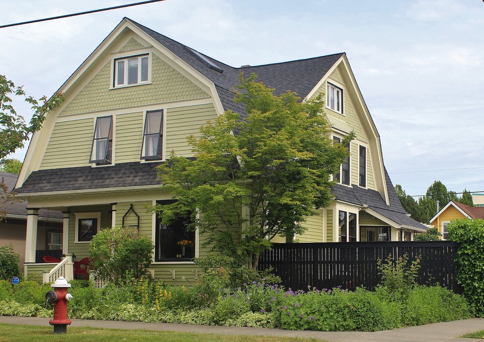 Пример оригинального дизайна: большой, трехэтажный, зеленый дом в викторианском стиле