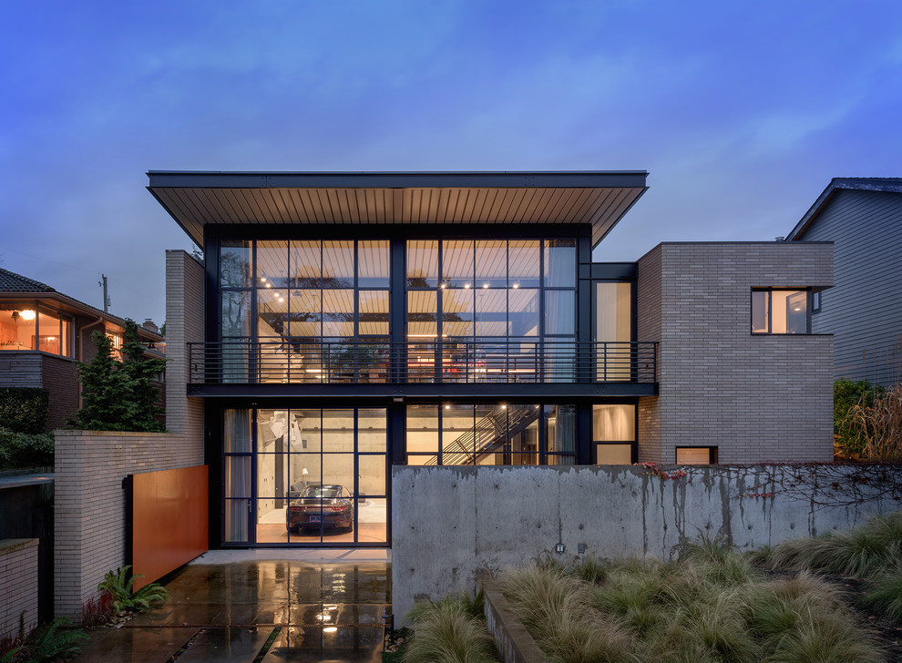 Zweistöckiges Industrial Einfamilienhaus mit Glasfassade, grauer Fassadenfarbe und Flachdach in Seattle