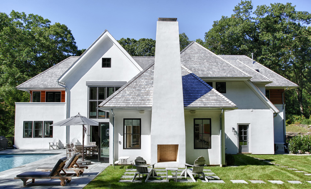 Example of a large transitional white two-story stucco exterior home design in New York with a hip roof