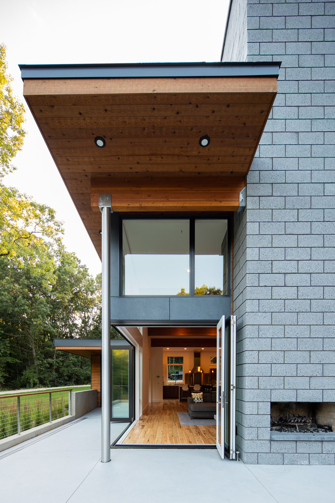 This is an example of a gey contemporary two floor house exterior in Grand Rapids with mixed cladding and a flat roof.