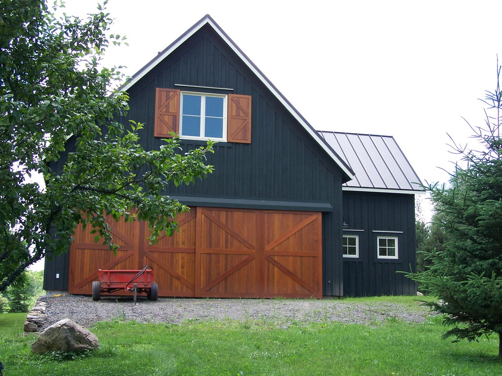 Réalisation d'une façade de maison noire champêtre en bois à un étage avec un toit à deux pans et un toit en métal.
