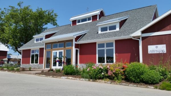 Cette photo montre une façade de maison rouge nature de taille moyenne et de plain-pied avec un revêtement en vinyle, un toit à deux pans et un toit en shingle.