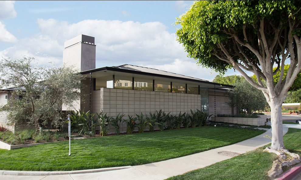 Inspiration for a 1950s gray one-story concrete house exterior remodel in Los Angeles with a hip roof and a metal roof