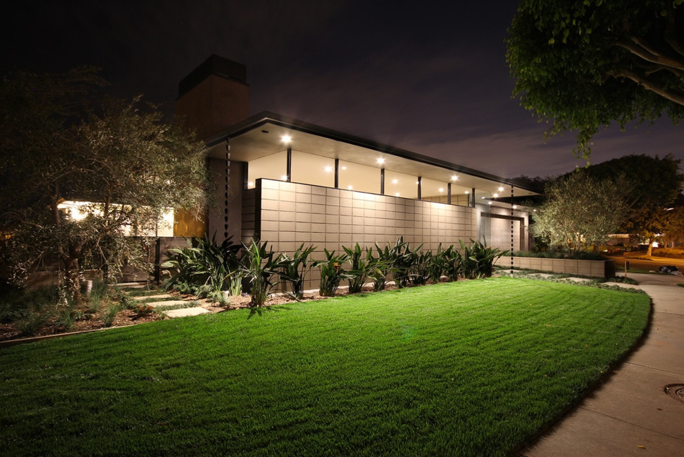 Inspiration for a mid-century modern gray one-story concrete house exterior remodel in Los Angeles with a hip roof and a metal roof