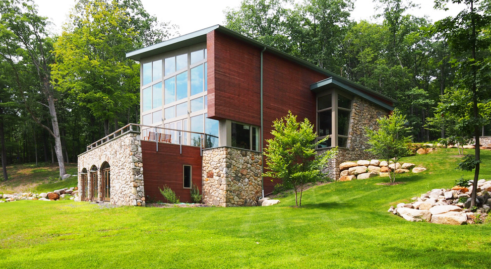 Ejemplo de fachada de casa roja rural grande de tres plantas con revestimientos combinados y tejado de un solo tendido