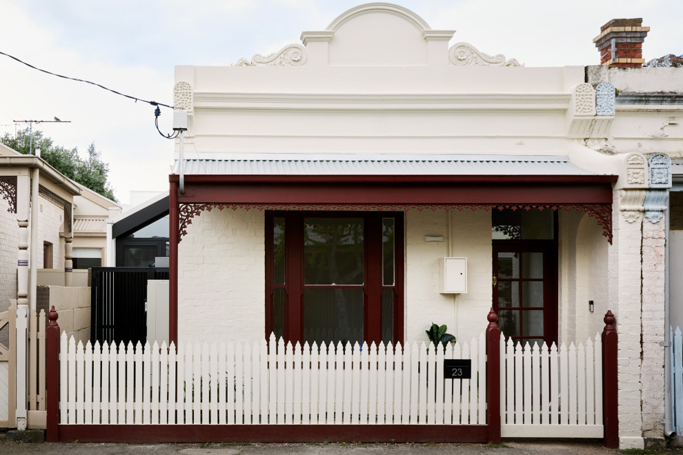 Kleines, Einstöckiges Klassisches Reihenhaus mit Mix-Fassade, weißer Fassadenfarbe, Satteldach und Blechdach in Melbourne