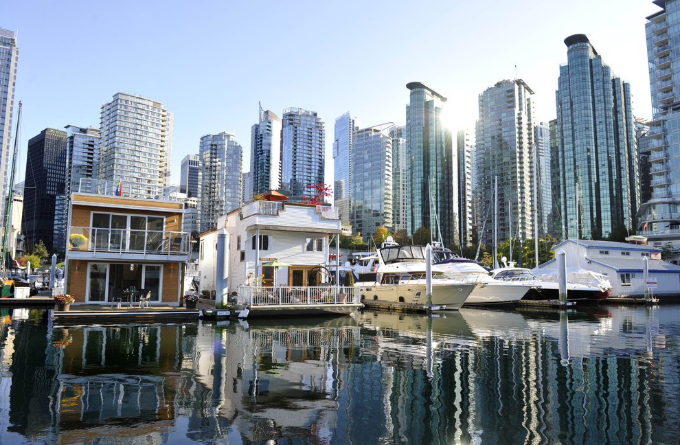 This is an example of a beach style two floor house exterior in Vancouver with a flat roof.