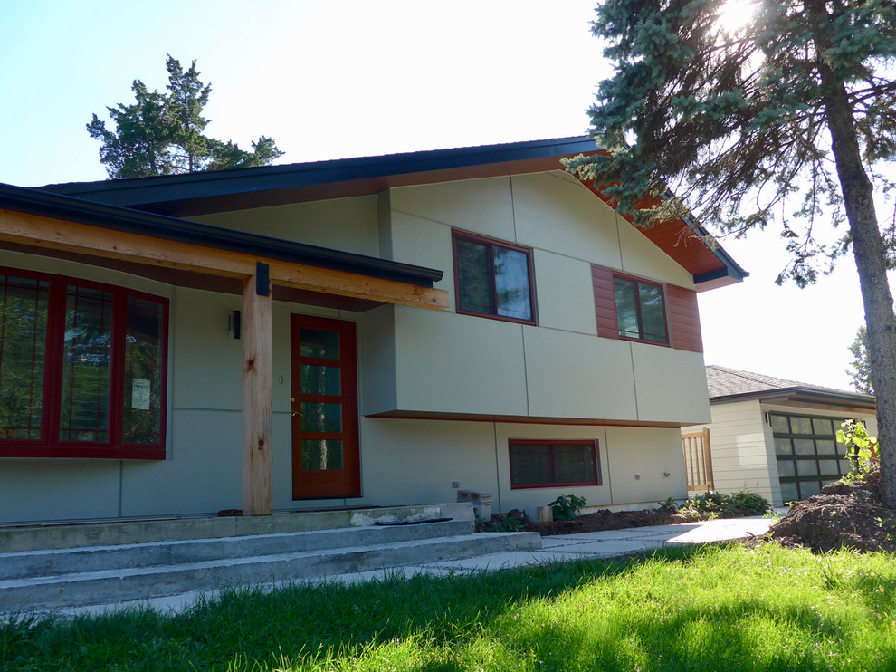 Ejemplo de fachada de casa beige contemporánea pequeña de dos plantas con revestimiento de aglomerado de cemento, tejado a dos aguas y tejado de teja de madera