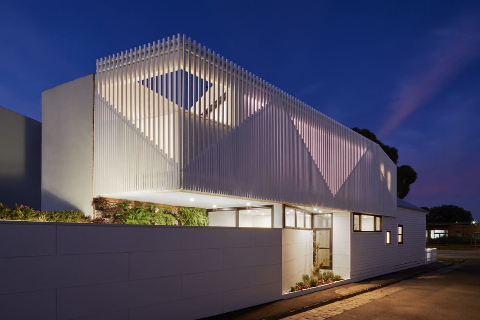 Kleines, Zweistöckiges Modernes Einfamilienhaus mit Metallfassade, weißer Fassadenfarbe, Flachdach und Blechdach in Melbourne