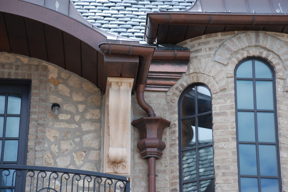 Imagen de fachada de casa marrón de estilo americano extra grande a niveles con revestimiento de piedra, tejado a la holandesa y tejado de teja de madera