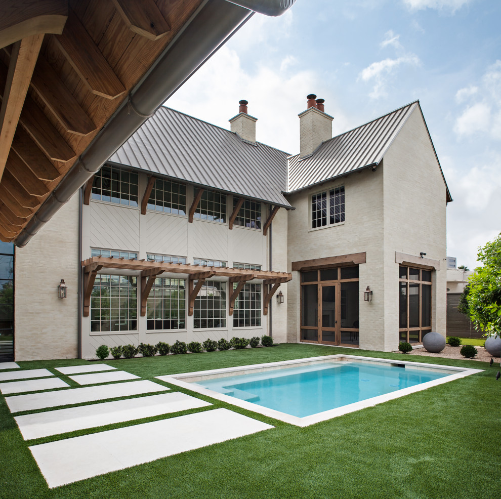 Exemple d'une grande façade de maison beige chic à un étage avec un revêtement mixte, un toit à deux pans et un toit en métal.