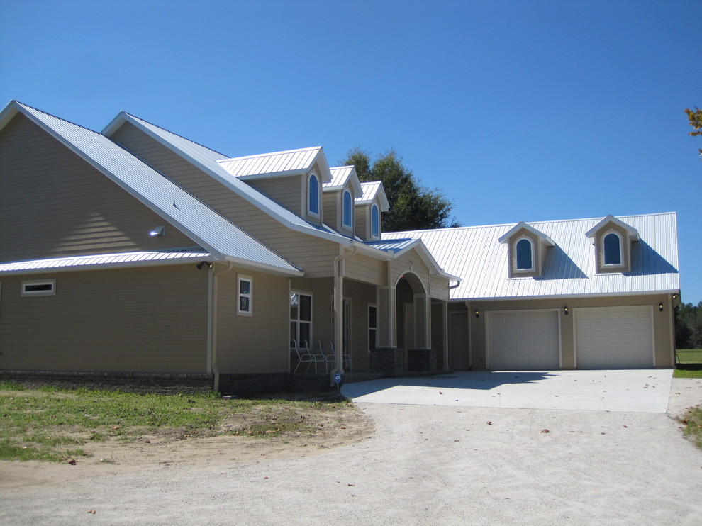 Exempel på ett stort klassiskt beige hus, med två våningar, fiberplattor i betong och sadeltak