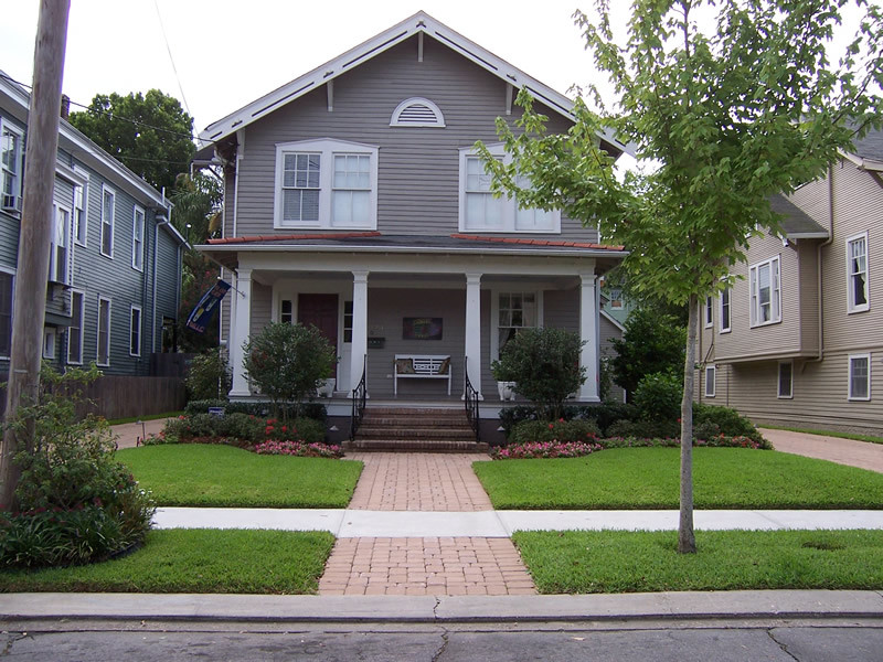 Photo of a medium sized and gey classic two floor house exterior in New Orleans with vinyl cladding and a half-hip roof.