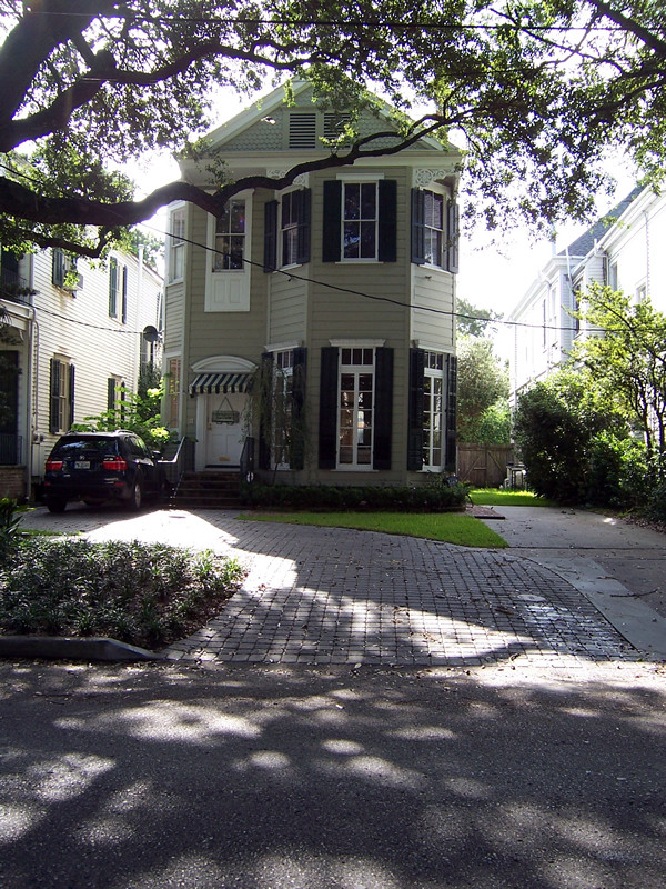 Mittelgroßes, Zweistöckiges Klassisches Haus mit Vinylfassade, grauer Fassadenfarbe und Halbwalmdach in New Orleans