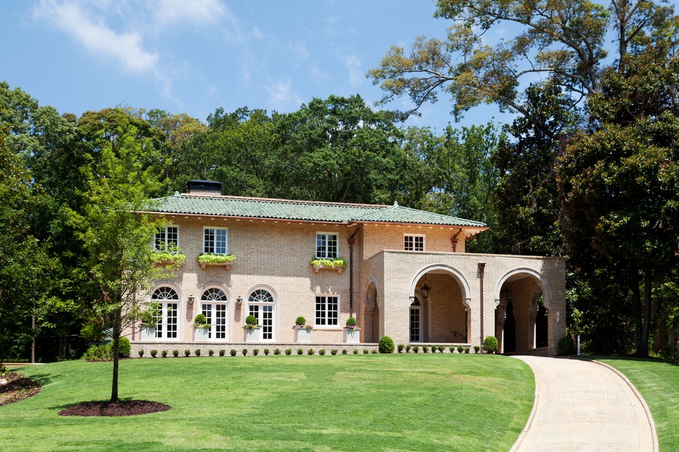 Immagine della facciata di una casa grande beige classica a due piani con rivestimento in mattoni
