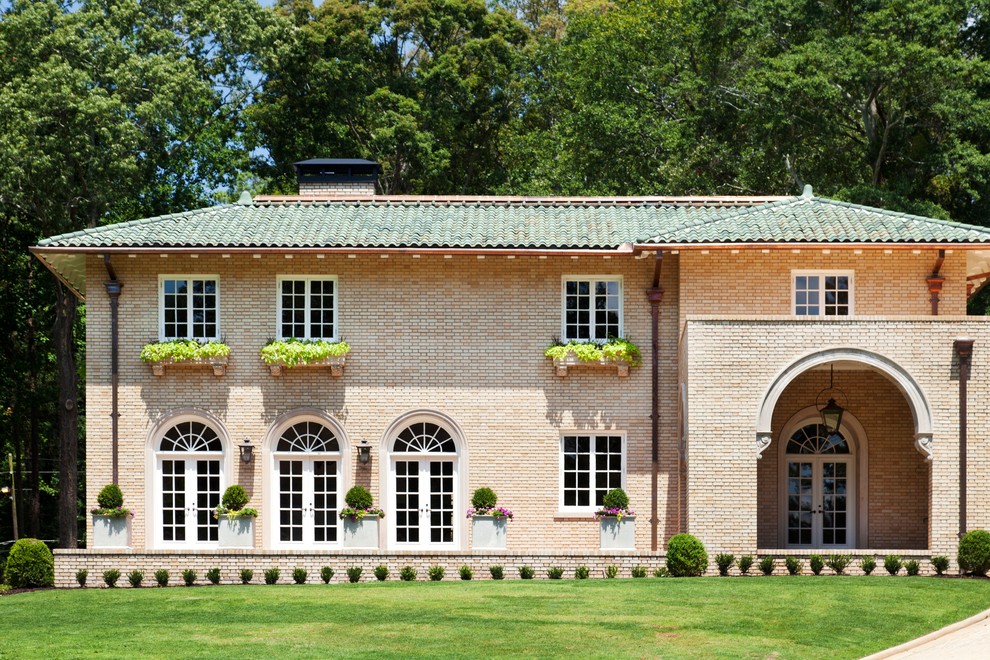 Ejemplo de fachada beige tradicional grande de dos plantas con revestimiento de ladrillo