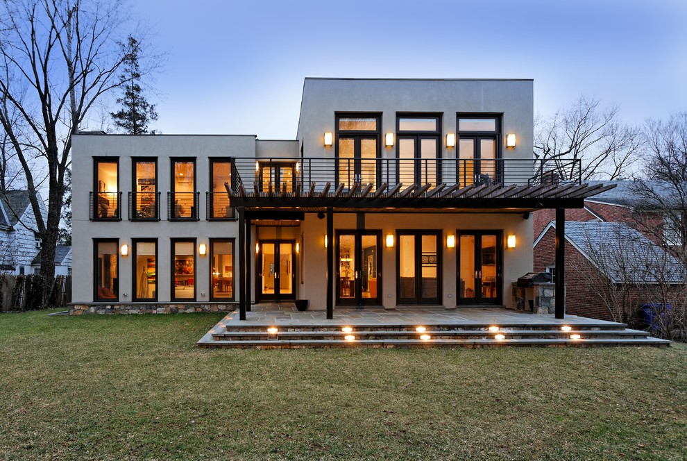 Стильный дизайн: двухэтажный, бежевый дом среднего размера в стиле неоклассика (современная классика) с облицовкой из цементной штукатурки - последний тренд