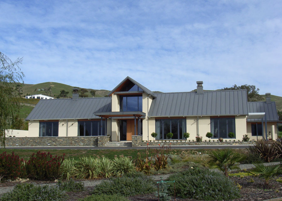 Aménagement d'une grande façade de maison blanche contemporaine en béton à un étage avec un toit à deux pans.