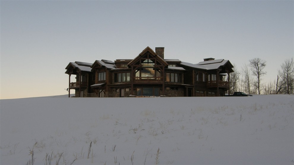 Exemple d'une grande façade de maison marron montagne en bois et planches et couvre-joints à un étage avec un toit à deux pans, un toit en shingle et un toit marron.