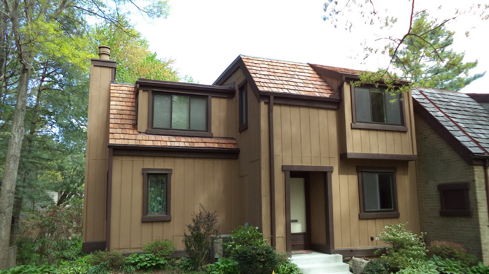 Imagen de fachada de casa marrón tradicional de tamaño medio de dos plantas con revestimiento de vinilo, tejado a cuatro aguas y tejado de teja de madera