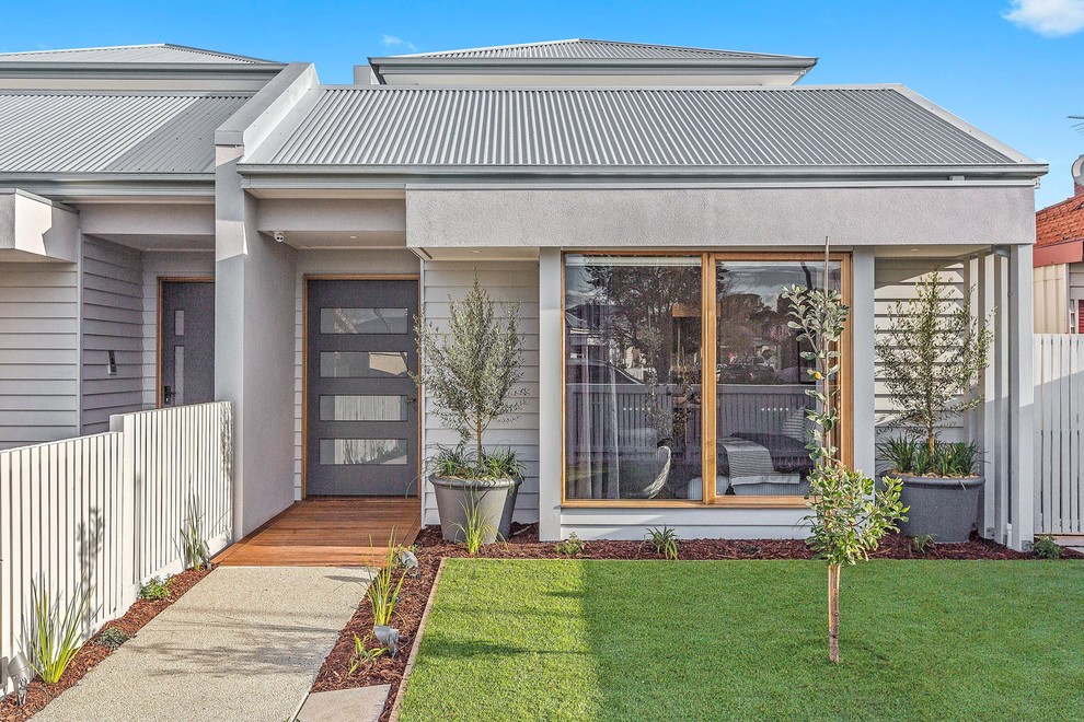This is an example of a medium sized and gey contemporary two floor terraced house in Melbourne with wood cladding, a pitched roof and a metal roof.