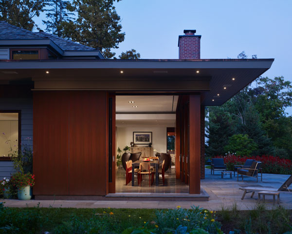 Inspiration for a large retro two floor house exterior in Chicago with wood cladding and a pitched roof.