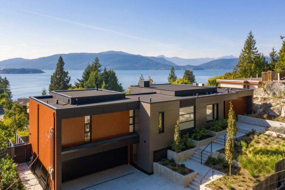 Photo of a large and brown contemporary two floor detached house in Vancouver with mixed cladding, a flat roof and a mixed material roof.