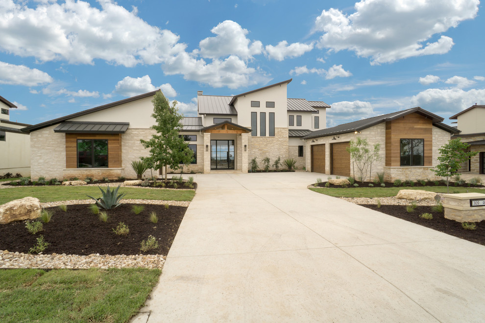 Photo of a large and beige two floor house exterior in Austin with stone cladding.