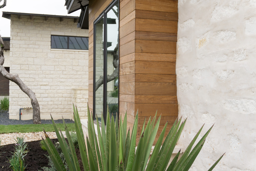 Großes, Zweistöckiges Modernes Einfamilienhaus mit beiger Fassadenfarbe, Steinfassade und Blechdach in Austin
