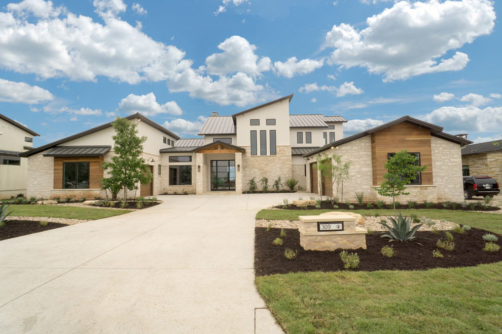 Photo of a large and beige contemporary two floor detached house in Austin with stone cladding and a metal roof.