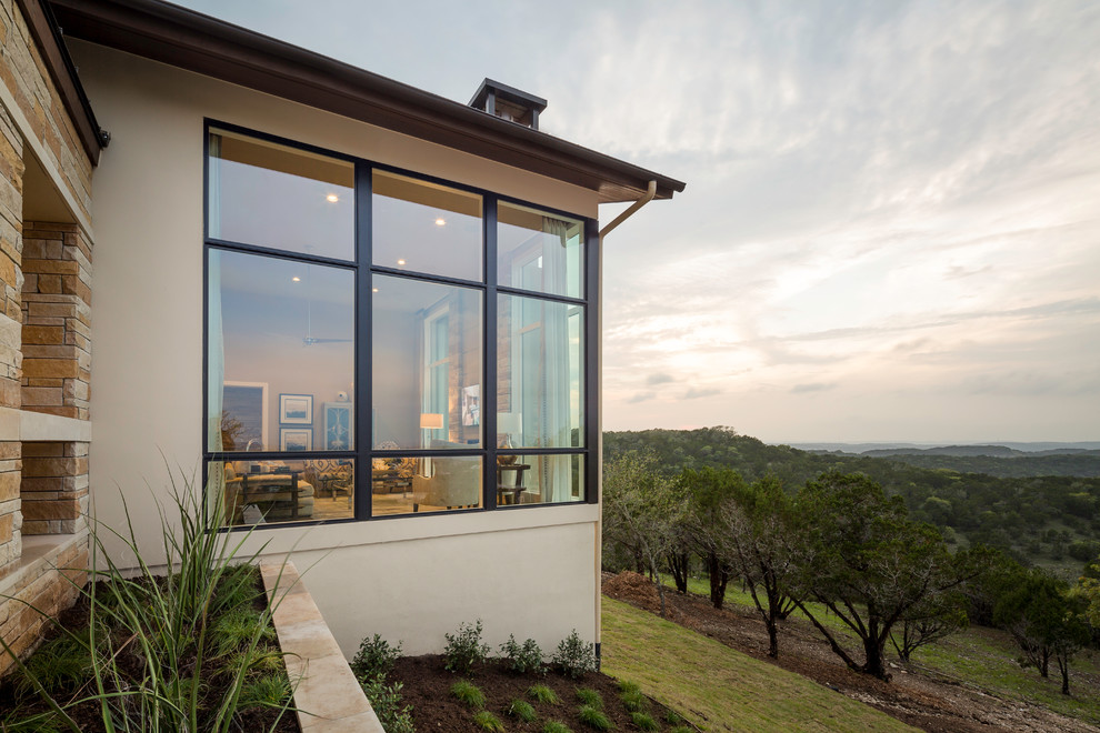 Beige contemporary two floor house exterior in Austin with stone cladding.