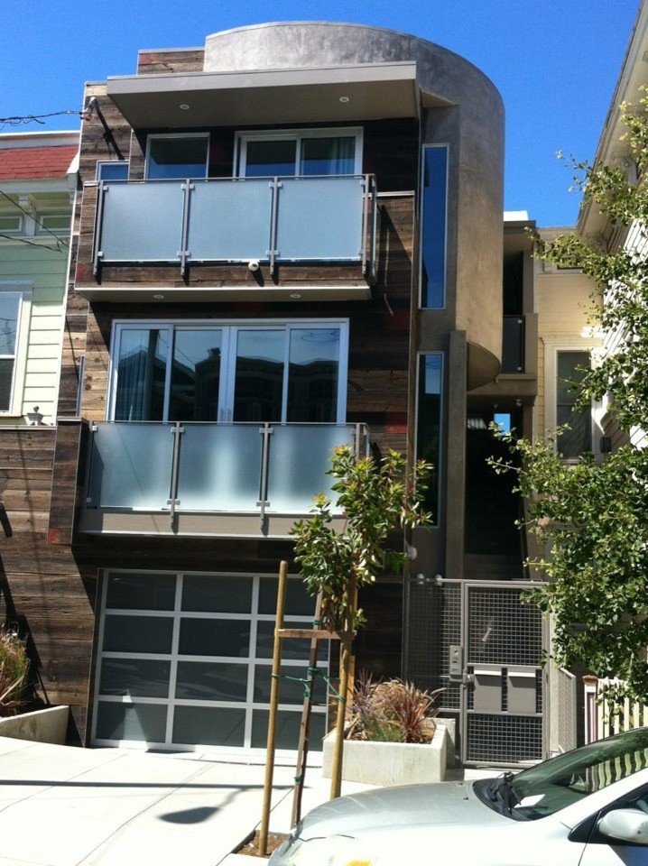 Cette photo montre une façade de maison grise moderne à deux étages et plus avec un revêtement mixte.