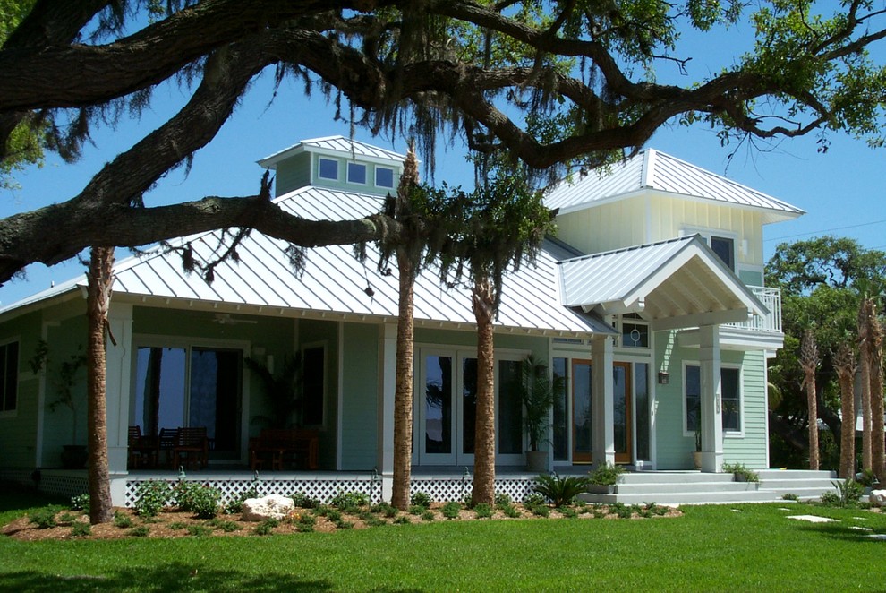 Ispirazione per la facciata di una casa verde stile marinaro a due piani di medie dimensioni con tetto a padiglione e rivestimento in legno