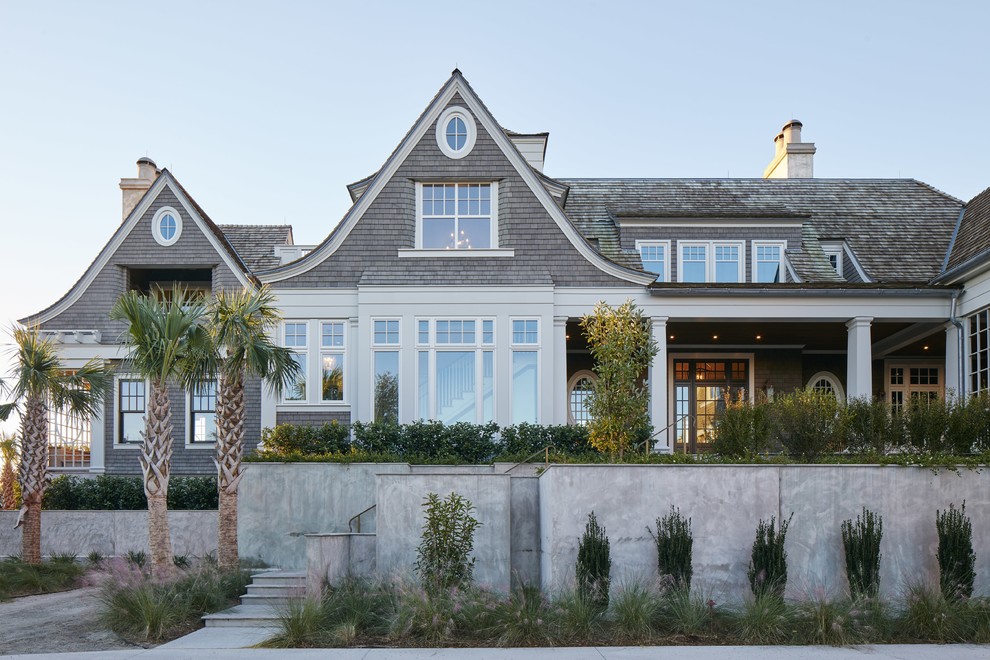 Cette photo montre une façade de maison grise bord de mer en bois à un étage avec un toit en shingle.