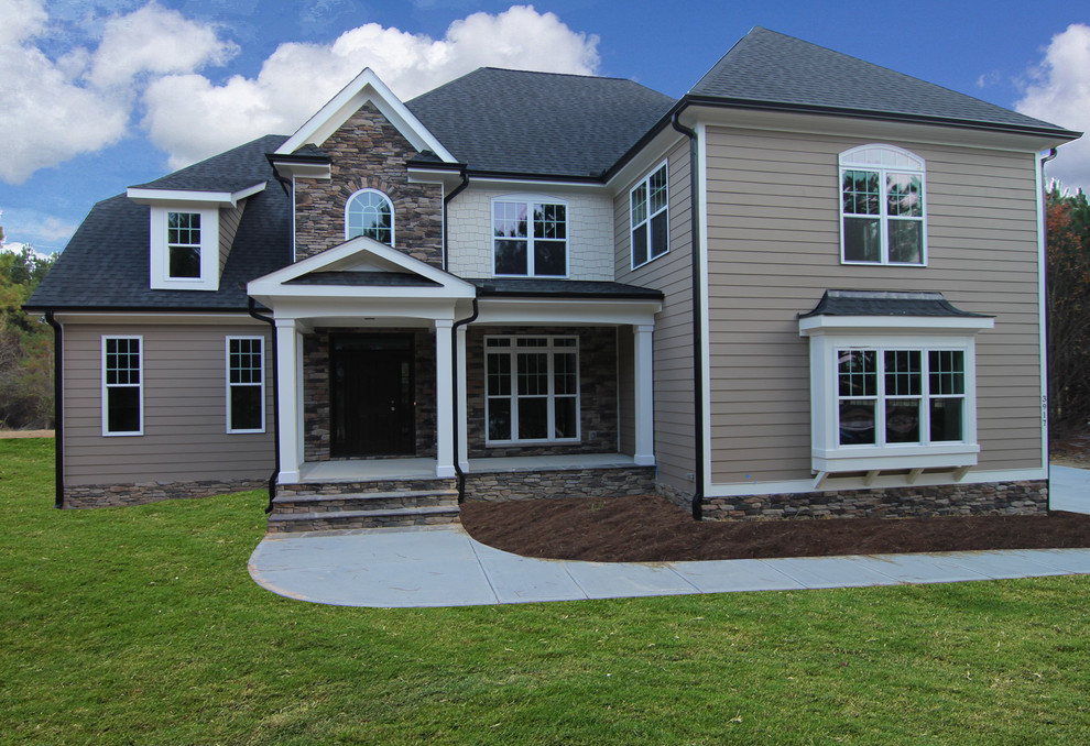 Design ideas for a large and beige traditional two floor house exterior in Raleigh with stone cladding.