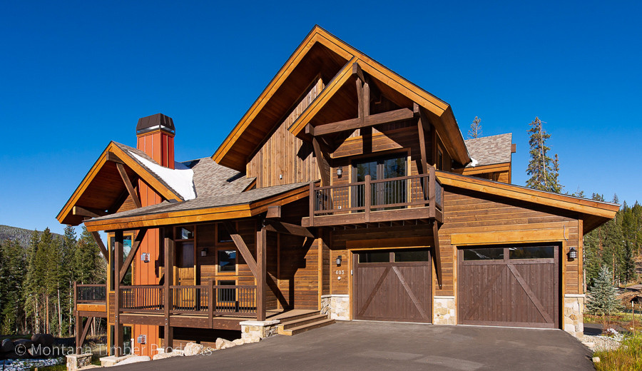 Foto de fachada de casa bifamiliar marrón rústica de dos plantas con revestimiento de madera y tejado de teja de madera