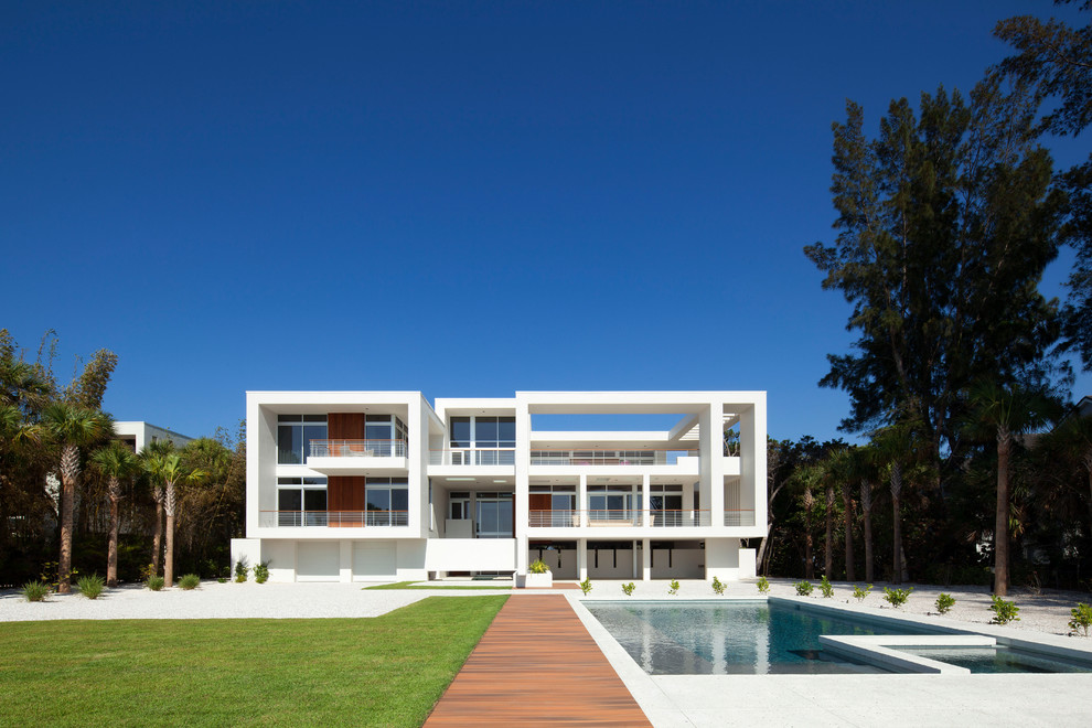 На фото: трехэтажный, белый дом в современном стиле