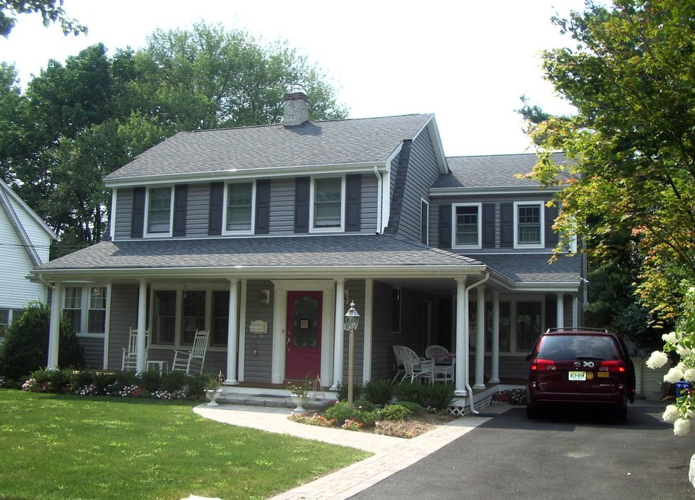 Exemple d'une façade de maison grise chic de taille moyenne et à un étage avec un revêtement en vinyle.