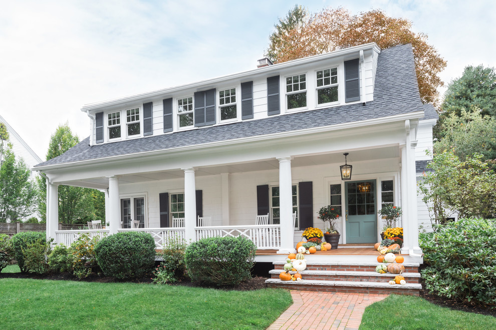 Imagen de fachada de casa blanca clásica grande de dos plantas con revestimiento de madera y tejado de teja de madera