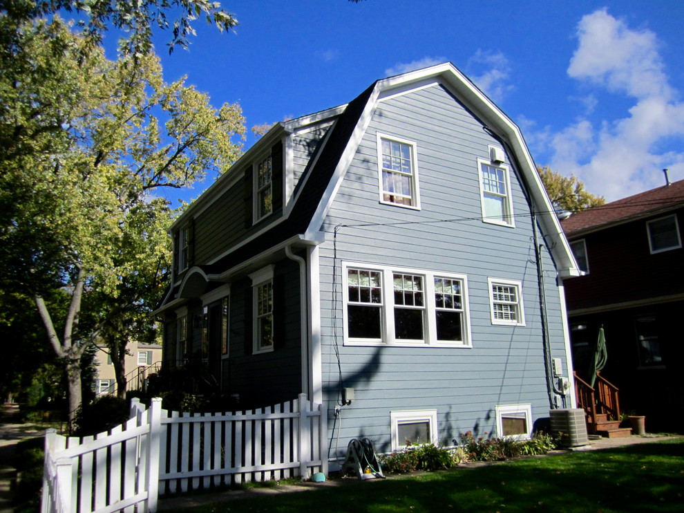 Cette image montre une façade de maison bleue traditionnelle en panneau de béton fibré de taille moyenne et à un étage avec un toit à deux pans et un toit en shingle.