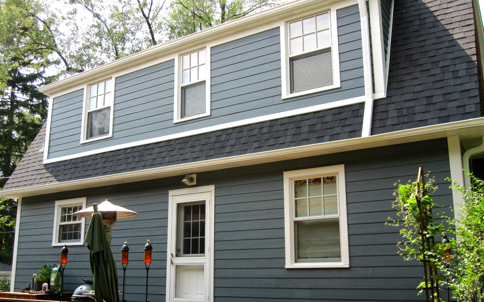 Ejemplo de fachada de casa azul tradicional de tamaño medio de dos plantas con revestimiento de aglomerado de cemento, tejado a dos aguas y tejado de teja de madera