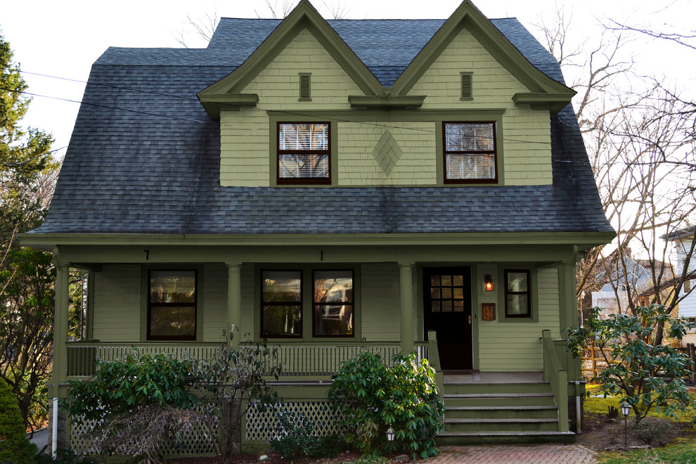 This is an example of a medium sized and green traditional two floor house exterior in New York with wood cladding and a mansard roof.