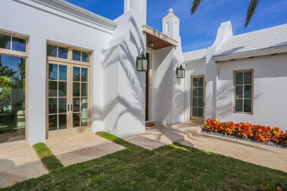 На фото: большой, двухэтажный, белый дом в морском стиле с облицовкой из цементной штукатурки и двускатной крышей