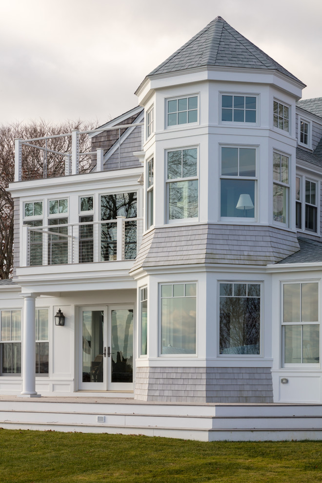 Idées déco pour une façade de maison grise bord de mer en bois de taille moyenne et à deux étages et plus avec un toit à deux pans.