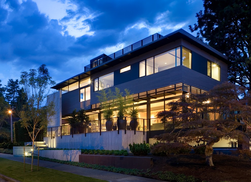 Cette image montre une façade de maison bleue design de taille moyenne et à un étage avec un revêtement mixte et un toit plat.