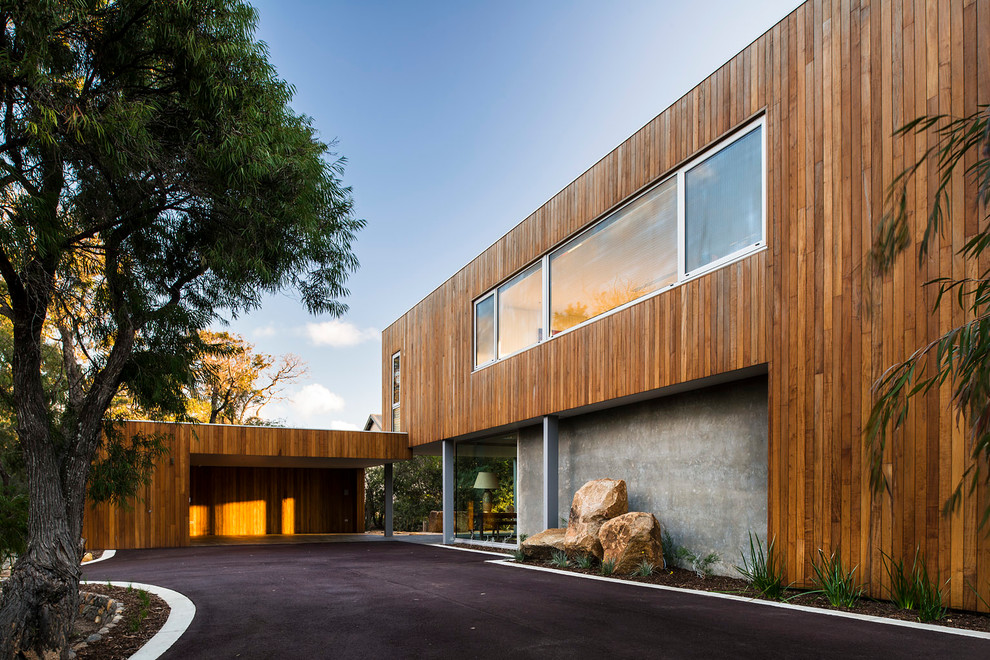 Cette photo montre une grande façade de maison moderne en bois à un étage avec un toit plat.